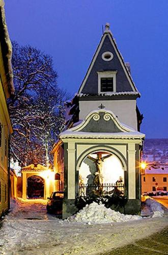 un edificio con una torre e una statua di fronte di Pension U Kapličky a Cesky Krumlov