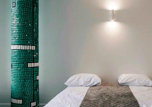 a bedroom with two beds and a light on the wall at Kyivpasservis Hotel in Kyiv
