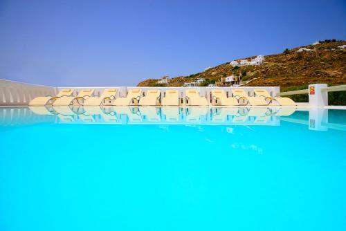 a row of chairs in the water at a resort at Paolas Sunset in Agios Stefanos