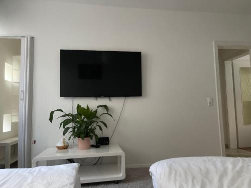 a living room with a flat screen tv on a wall at Trier City Center Apartments & Stadthaus, Zentrum in Trier