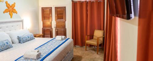 a bedroom with a bed and a chair in it at Island Magic Beach Resort in Caye Caulker