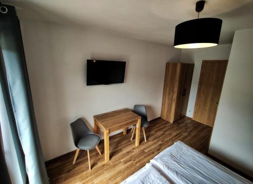 a room with a table and two chairs and a television at Willa Kania in Szczawnica