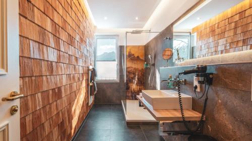 a bathroom with a sink and a brick wall at Villa Sonnenhof Boutique-Hotel in Bad Reichenhall