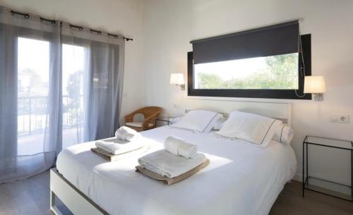 1 dormitorio con 1 cama blanca grande y toallas. en Luna Bay Palma en Palma de Mallorca