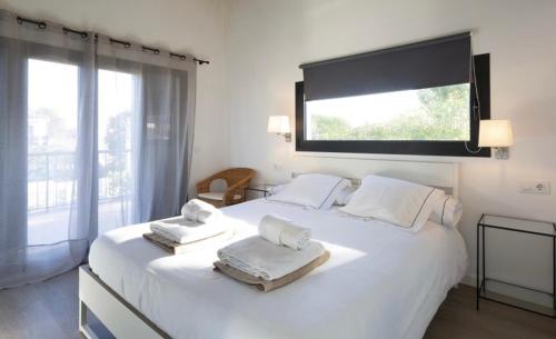 1 dormitorio con 1 cama blanca grande y toallas. en Luna Bay Palma, en Palma de Mallorca