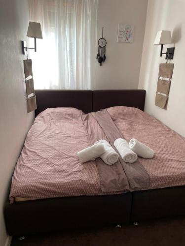 a bed with two pairs of towels on it at Lola Apartment, Župa Wellness & Spa, Kopaonik in Kopaonik