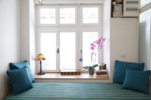 a living room with a window and a couch with blue pillows at Ohrid Center Galerie House in Ohrid