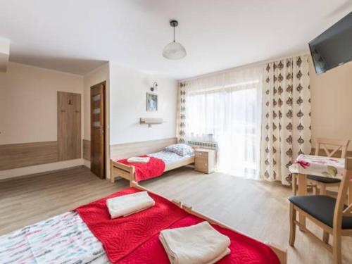 a bedroom with two beds and a desk and a window at OW JĘDRUŚ in Zawoja