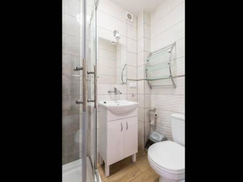 a white bathroom with a toilet and a sink at OW JĘDRUŚ in Zawoja