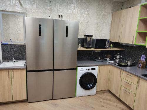 a kitchen with a refrigerator and a washing machine at STAR CITY Hostel in Kyiv