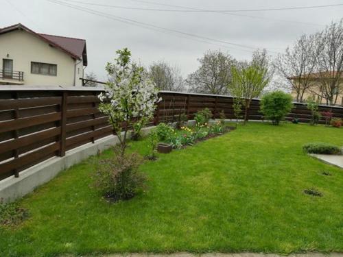 een achtertuin met een hek en een tuin met planten bij Untold 2024 - 3-room apartment with garden for 6-8 person, 2 private parking in Cluj-Napoca