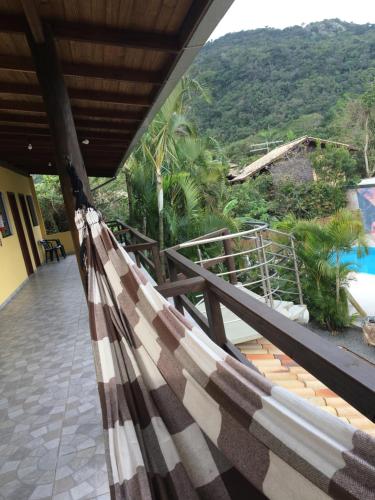a hammock on a balcony with a view of a mountain at Morada do Gabriel in Guarda do Embaú