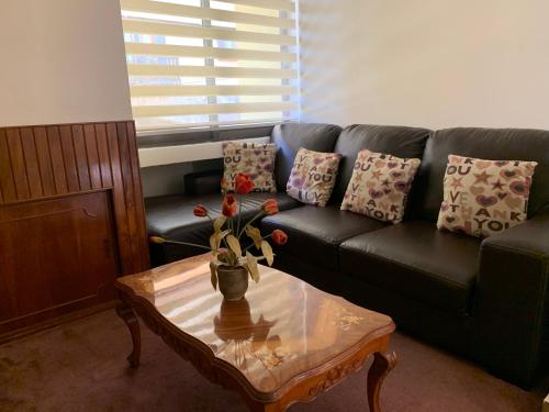 a living room with a black couch and a coffee table at Casa Galindo *a unos pasos del centro* in Zacatlán