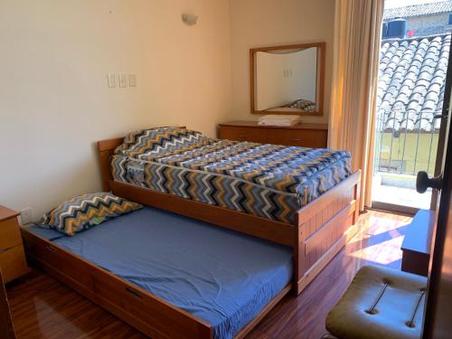 a bedroom with a bed and a mirror and a window at Casa Galindo *a unos pasos del centro* in Zacatlán