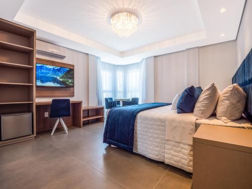 グラマドにあるHotel Locanda Casa D'Oroのベッドとテレビがあるホテルの部屋