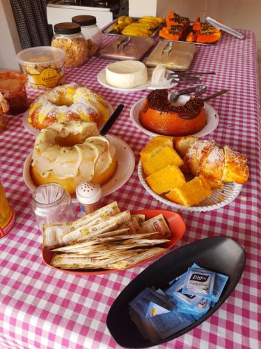 uma mesa com pratos de donuts e pastelarias em Pousada Recanto do Lago 1 em Capitólio