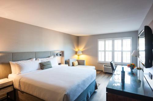 Cette chambre comprend un grand lit et un bureau. dans l'établissement Hotel Indigo Napa Valley, an IHG Hotel, à Napa