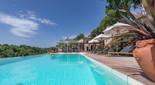 a swimming pool in front of a house at Borgo Baccile by Vini Fantini in Crecchio