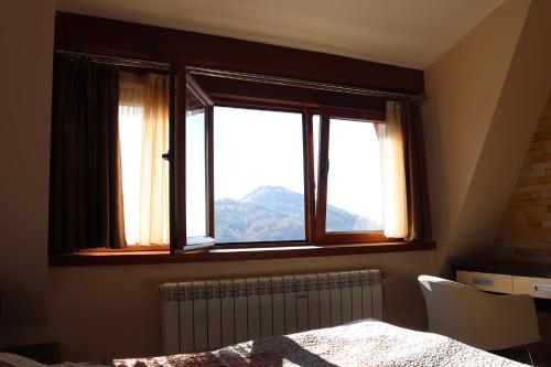 a bedroom with a window with a view of a mountain at Apartman Snesko Zoned in Kopaonik