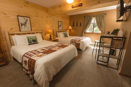 a bedroom with two beds in a log cabin at The Snowed Inn in Killington
