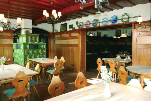 une salle à manger avec des tables et des chaises en bois dans l'établissement Gasthof Schiller bei Bamberg, à Strullendorf