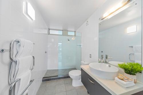 a white bathroom with a sink and a toilet at Affordable One Bedroom Apartment Lake Taupo C4 in Taupo