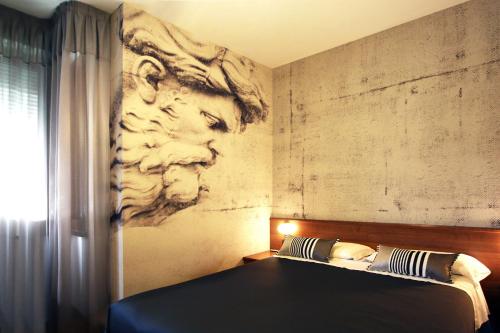 1 dormitorio con 1 cama con una pintura en la pared en Park Hotel Meublé en Como