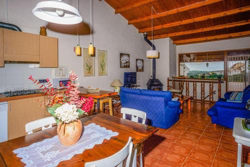 a kitchen and dining room with a table and blue chairs at Habitour - Casa la Cenia in Cervera del Maestre