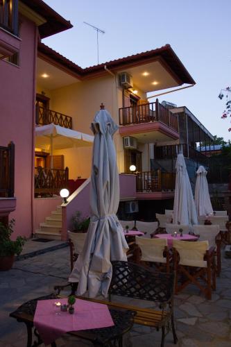 a restaurant with tables and umbrellas on a patio at Hotel Ismini in Ammouliani