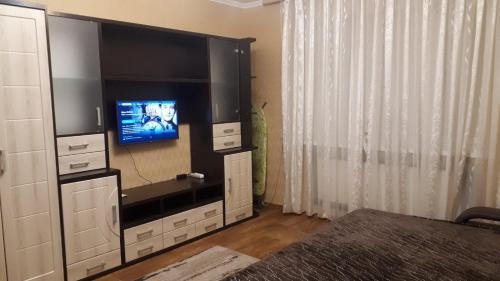 uma sala de estar com televisão num centro de entretenimento em Апартаменты, 2 комн. 6 мест em Kropyvnytskyi