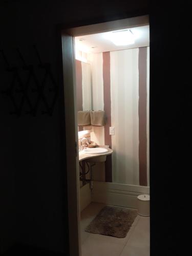 y baño con lavabo y espejo. en Casa Planalto, en Gramado