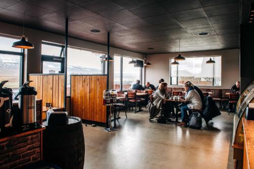 a group of people sitting at tables in a restaurant at North West Restaurant & Guesthouse in Víðigerði