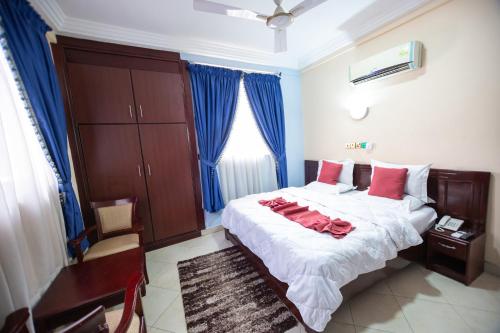 a bedroom with a large bed with red pillows at SWEET PEE EXECUTIVE HOTEL in Ayeduasi