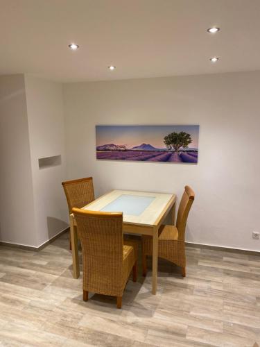 a dining room table with chairs and a painting on the wall at Range Erholungs FEWO in Cottbus
