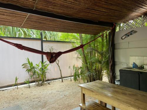 a hammock in a room with a table and some plants at Beach Cabinas in Santa Teresa Beach