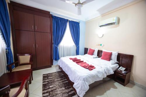Un dormitorio con una cama con almohadas rojas. en SWEET PEE EXECUTIVE HOTEL, en Ayeduasi