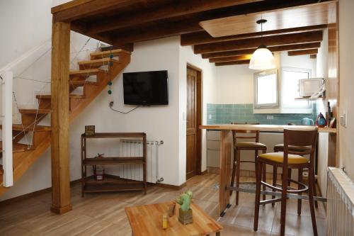 un soggiorno con una scala e una cucina con un tavolo di Meraki Lofts a El Chalten