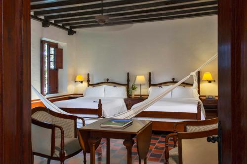 坎佩切的住宿－Hacienda Campeche，一间卧室配有两张床和一张桌子及椅子