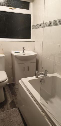 a bathroom with a sink and a tub and a toilet at Cosy 3 bedroom residential house, private garden, 30 minutes from Alton Towers, 5 minute walk to Trentham Gardens. in Stoke on Trent