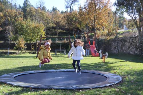 Deux fillettes sautant sur un trampoline dans l'établissement Encosta do Sobreiro - Serra da Estrela, à Fornos de Algodres
