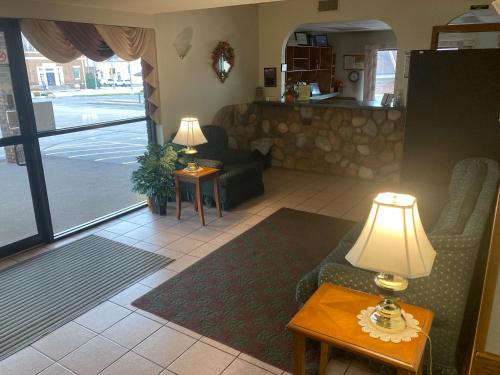 uma sala de estar com um sofá e uma mesa com um candeeiro em Landmark Motel em Clintonville