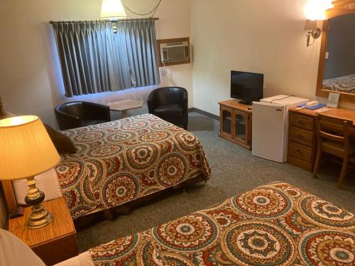 a hotel room with two beds and a television at Landmark Motel in Clintonville