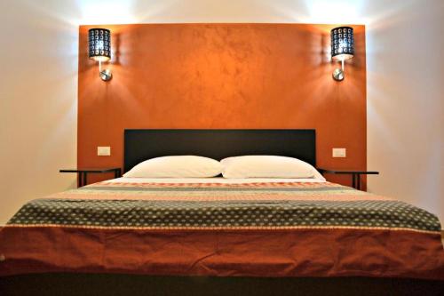 a bedroom with a large bed with an orange wall at Key of Venice Guest House in Venice