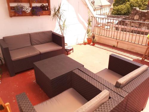 Un canapé et des chaises sont installés sur la terrasse. dans l'établissement SX6 Ático con terraza en centro histórico Pontevedra, à Pontevedra