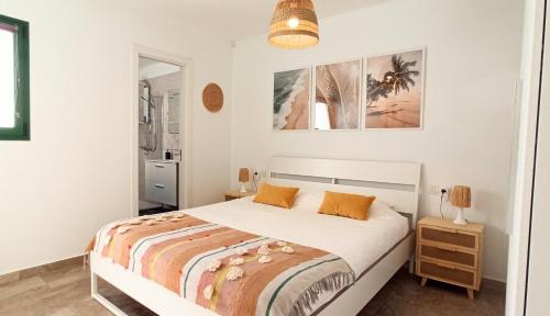 プエルト・デル・カルメンにあるApartment Paraiso III - Piscina - Wifiのベッドルーム1室(白いベッド1台、オレンジ色の枕付)