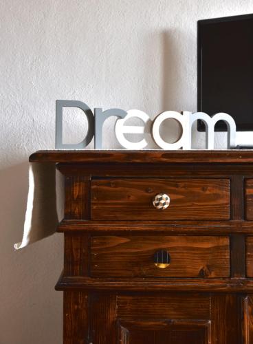 a wooden dresser with a sign on top of it at Il Giglio B&B in Pienza