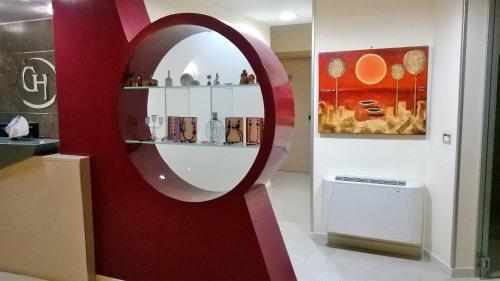 lustro w pokoju z czerwoną ścianą w obiekcie Hotel Ginevra w mieście Poggiomarino
