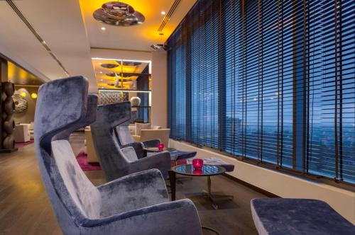 a waiting room with chairs and tables and a large window at Radisson Blu Hotel, Nairobi Upper Hill in Nairobi