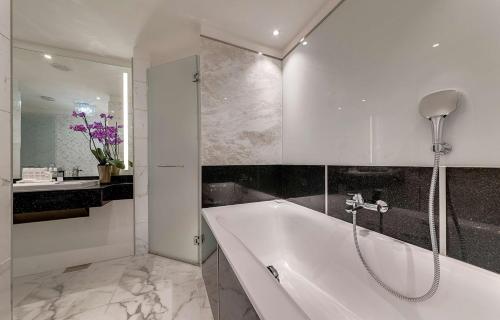 a white bathroom with a tub and a sink at Radisson Blu Hotel, Nairobi Upper Hill in Nairobi