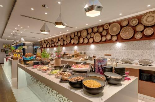 a buffet line with bowls of food in a restaurant at Radisson Blu Hotel, Nairobi Upper Hill in Nairobi